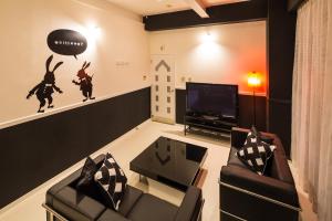 a living room with two chairs and a tv at Hotel Aqua Color (Adult only) in Fukushima