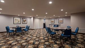 une salle de conférence avec deux tables et des chaises ainsi qu'un podium dans l'établissement Best Western New Albany, à New Albany