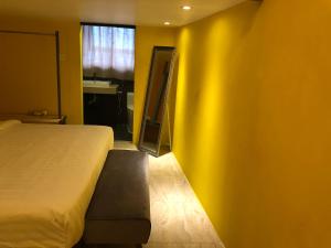 a bedroom with a bed and a yellow wall at The Wharf in Semporna