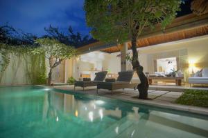 a swimming pool in a backyard with a villa at Villa Bali Asri Batubelig in Seminyak