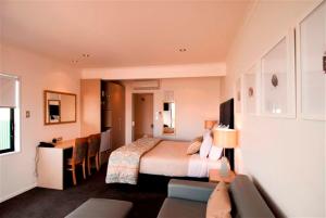 a hotel room with a bed and a desk and a room at Marineland Beachfront Accommodation in Napier +58 photos