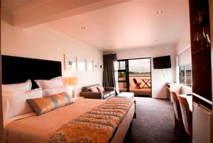 a bedroom with a large bed and a living room at Marineland Motel in Napier
