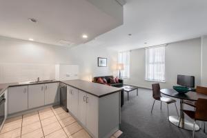 a kitchen and living room with a couch and a table at Franklin Apartments in Adelaide