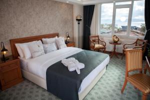 a hotel room with a bed with a robe on it at Tuzla Garden Hotel & Spa in Tuzla