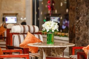 a vase of white flowers sitting on a table at Long Bao Chau Hotel in Thu Dau Mot