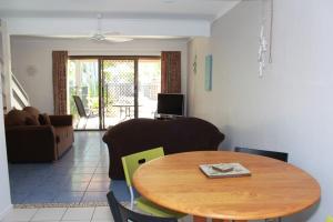 a dining room with a table and a living room at Noosa Sound Resort Noosaville in Noosaville