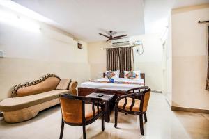 FabHotel Aditya Yatri Nivas في تيروباتي: غرفة بسرير وطاولة وأريكة