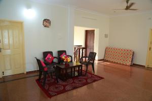 uma sala de estar com uma mesa e cadeiras num quarto em Coimbatore Home Stay & Serviced Apartment em Coimbatore