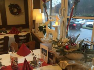 Landhotel Menke في بريلون: غرفة بها طاولة عليها زينة عيد الميلاد