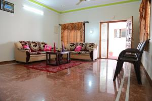 uma sala de estar com dois sofás e uma mesa em Coimbatore Home Stay & Serviced Apartment em Coimbatore