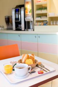 a tray with a plate of bread and a cup of coffee at Premiere Classe Annecy Nord - Epagny in Épagny