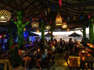 un groupe de personnes assises dans un bar à la plage dans l'établissement Blue Andaman Lanta Resort, à Ko Lanta