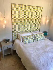 1 dormitorio con 1 cama con cabecero amarillo en Maison Malherbe en Franschhoek