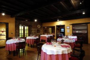 a dining room with tables with red and white tablecloths at La Rectoral in Taramundi