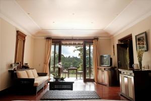 a living room with a couch and a tv at Anhera Suite Ubud in Ubud