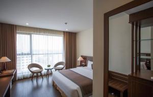 Quang TriにあるMuong Thanh Grand Quang Tri Hotelのベッドと大きな窓が備わるホテルルームです。