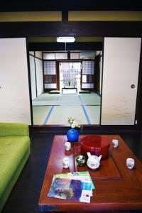 Guesthouse Mio في أوميهاتشيمان: غرفة معيشة مع طاولة وغرفة مع بلاط