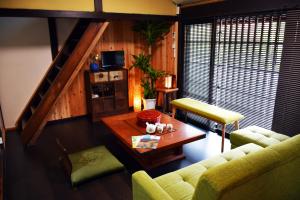 uma sala de estar com um sofá e uma mesa em Guesthouse Mio em Omihachiman