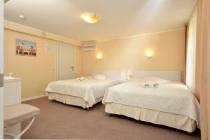 Habitación con 2 camas y sábanas blancas. en light hotel & hub, en Kiev
