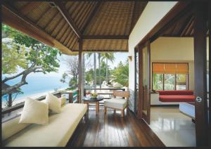 a living room with a couch and a view of the ocean at Qunci Villas Resort in Senggigi