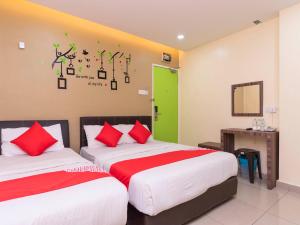 a bedroom with two beds with red and green accents at I Leaf Boutique Hotel in Johor Bahru