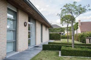 un edificio in mattoni con un passaggio pedonale accanto a un albero di VILLA WESTHOEK a Poelkapelle