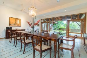 una sala da pranzo con un grande tavolo in legno e sedie di Niketh Villa Kandy a Kandy