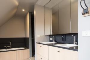 a kitchen with white cabinets and two sinks at VILLA WESTHOEK in Poelkapelle +90 photos