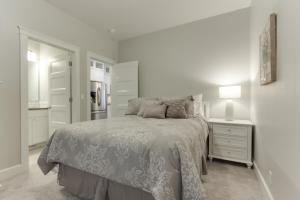 ein weißes Schlafzimmer mit einem Bett und einem Nachttisch in der Unterkunft 6th Street Retreat in Coeur d'Alene