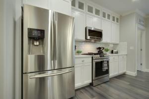 einen Kühlschrank aus Edelstahl in einer Küche mit weißen Schränken in der Unterkunft 6th Street Retreat in Coeur d'Alene