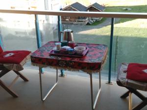einen Tisch mit einem Tablett mit Speisen auf dem Balkon in der Unterkunft Appartement traversant résidence chaput 2 - 2 pièces - 6 personnes - vue sur front de neige in La Toussuire