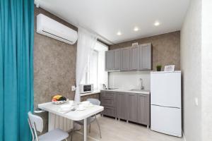a kitchen with a table and a white refrigerator at Центр!!! Уют!!! Чистота!!! #1 in Novosibirsk