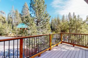 a balcony with a wooden railing and trees at Serene Retreat in Soda Springs