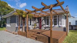 a pergola on a deck in front of a house at Central Rotorua Beauty in Rotorua