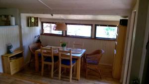 a dining room with a wooden table and chairs at Bory Tucholskie Domek in Skorzenno