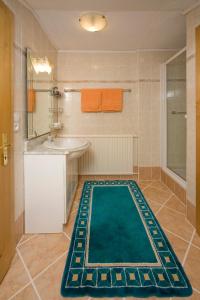 a bathroom with a green rug on the floor at Haus Alpenglühn in Abtenau