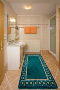ein Badezimmer mit einem grünen Teppich auf dem Boden in der Unterkunft Haus Alpenglühn in Abtenau