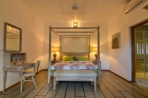a bedroom with a canopy bed and a desk at Niketh Villa Kandy in Kandy