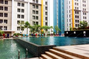 a swimming pool in a city with tall buildings at Parquette Studio at Paramount Skyline Apartment By Travelio in Tangerang