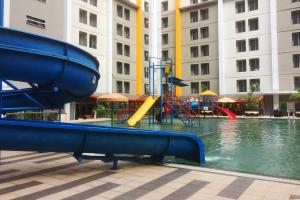 a playground with a slide in a pool of water at Parquette Studio at Paramount Skyline Apartment By Travelio in Tangerang +2 photos