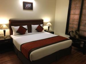 a bedroom with a large bed and two lamps at La Residence in Gurgaon