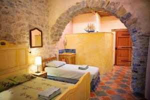 a bedroom with two beds in a room with an arch at The Balcony Gîte - Riverside Lagrasse in Lagrasse