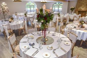 a banquet hall with white tables and chairs with candles at The Mill at Conder Green in Conder Green