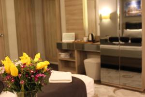 una habitación de hotel con un jarrón de flores sobre una mesa en BC Residence Pangaldi, en Estambul