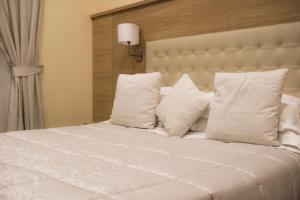 een groot wit bed met witte kussens bij Esposizione Palace Hotel in Rome