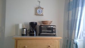 a microwave on top of a wooden cabinet with a clock at Haus Bergpanorama in Immenstadt im Allgäu