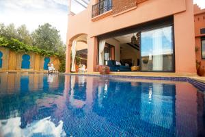 a swimming pool in front of a house at VILLA ILYANA in Marrakesh
