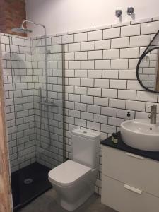 a white bathroom with a toilet and a sink at Suites La Catedral in León