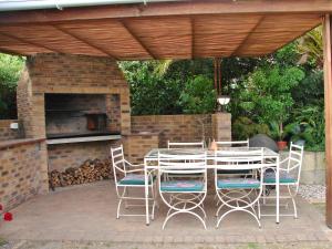 a patio with a table and chairs and a fireplace at Majorca House in Somerset West