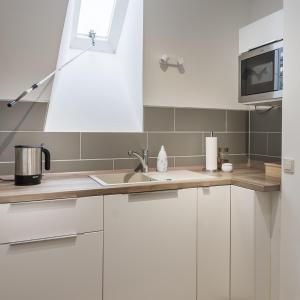 a kitchen with white cabinets and a sink at Haus Biederstaedt in Ottersberg